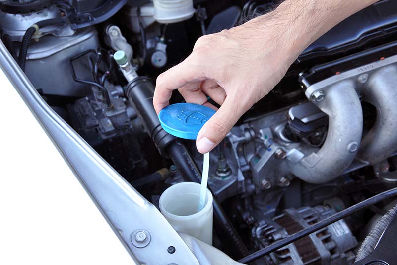 Person checking the fluid in the engine during an RV inspection